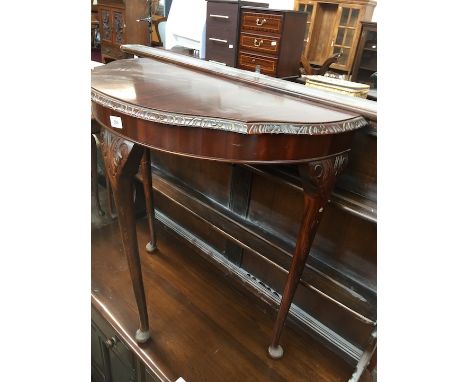 A reproduction carved console table. 