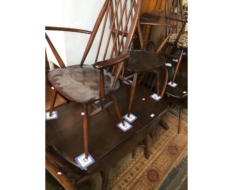 An Ercol dark elm and beech drop leaf tables and four chairs. 