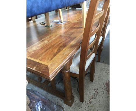 A parquetry inlaid hardwood dining table and four ladder back chairs. 