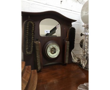 A hall mirror with brushes and barometer. 