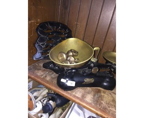 A cast metal book stand and a cast iron Boots chemists set of scales with brass trays and weights. 