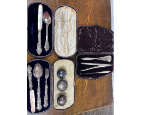 A boxed silver three piece flatware set and one other, three silver tops for perfume bottles and boxed set of silver handle b