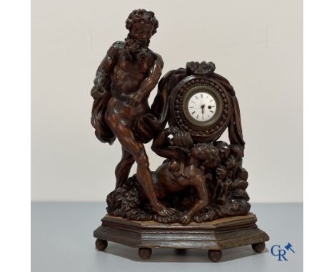 An 18th century wood carved table clock with finely chiseled English watchwork (London). Signed. | 34.5 x 25.5 x 10 cm.