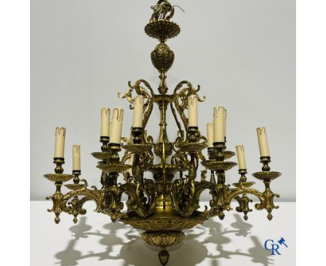 A large bronze chandelier with 16 light points and a matching wall lamp. | 93 x 80 cm.
