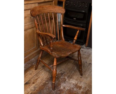 A 19th century beech and elm kitchen armchair with stick back and solid seat, on turned legs with 'H' stretcher