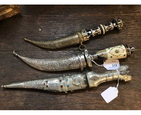 Three Indian daggers, the first with a bone &amp; horn grip and white metal scabbard, another all white metal with beaded dec