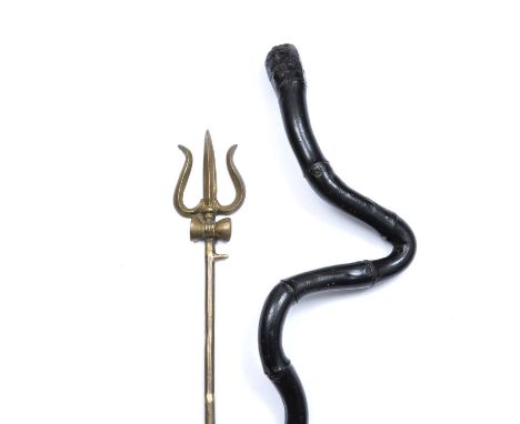 An Indian brass Trisul or trident c.1930 on stand, 52cm long; and an ebonised stick in the form of a cobra, 92cm long (2)