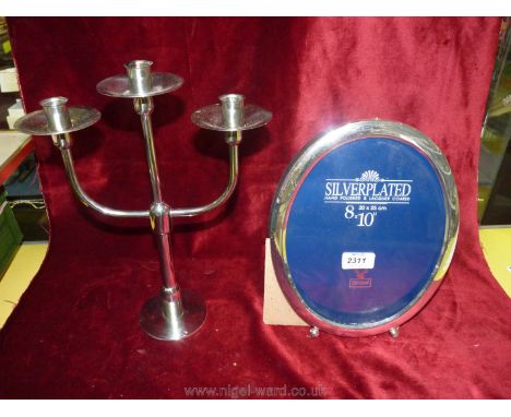 A silver plated candelabra by Robert Welch and a plated frame.