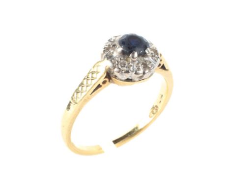 An 18ct yellow gold sapphire and diamond cluster ring, the central blue stone surrounded by six illusion set diamonds, ring s