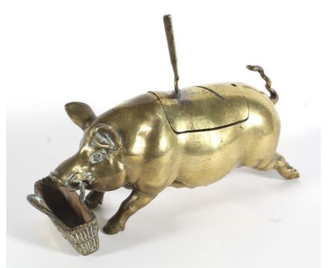 An inkwell or cruet stand cast as a brass pig before a basket spoon or pen-rest, with glass liner, the basket titled Bon Appe