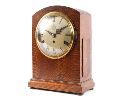 A World War II era oak cased RAF fusee mantel clock, of arched rectangular form, the silvered dial with crowned RAF emblem an