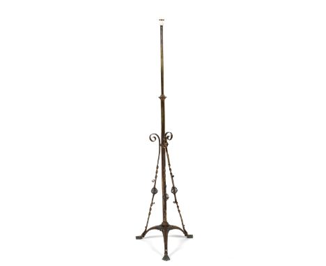 An Arts and crafts brass standard lamp, the column with three brass ropetwist supports terminating on a tripod base to lion p