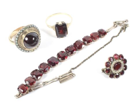 An assortment of 9ct and 14K gold and garnet set jewellery to include two rings, a brooch and bracelet, 12.1g and a 14k dress