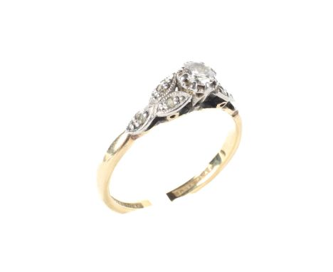 An 18ct gold and platinum set diamond solitare ring, the central stone flanked by three leaves to the shoulder, each leaf set