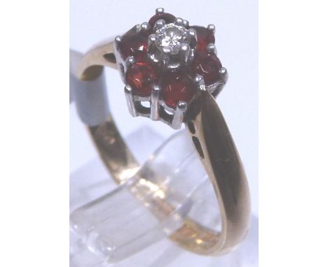 DIAMOND & GARNET CLUSTER RING. 9 ct gold garnet and diamond daisy cluster ring, size K