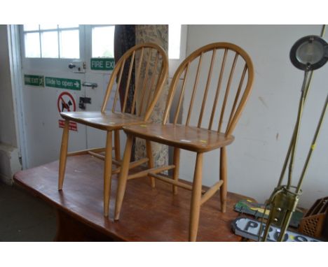 A pair of light Ercol stick back dining chairs