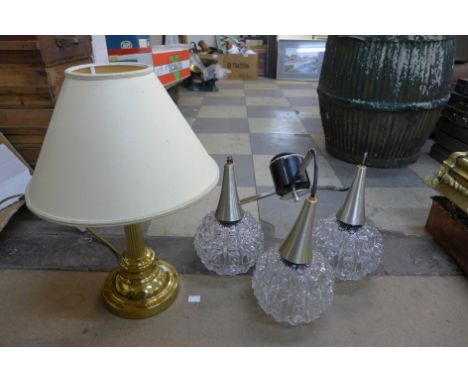 A brass table lamp and a mid 20th Century three branch hanging pendant light 