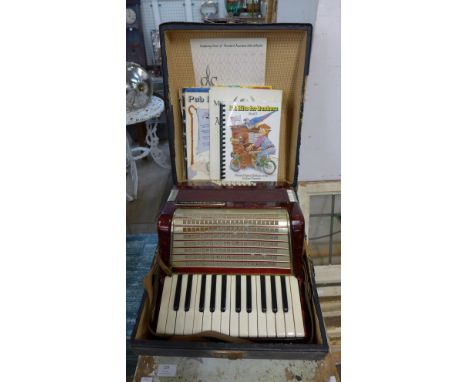 A Worldmaster accordion with sheet music, boxed 