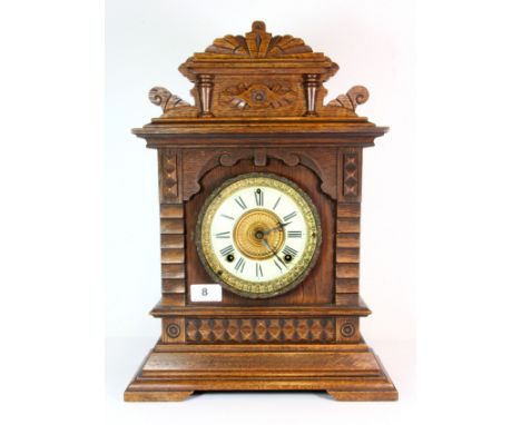 A late 19th / early 20th century Ansonia (American) carved beech mantle clock of architectural form, raised on small bracket 