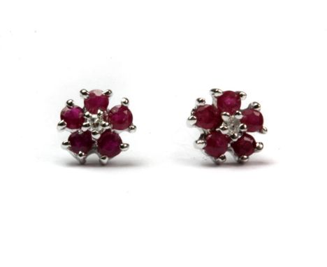 A pair of 9ct white gold (stamped 9k) ruby and diamond set flower shaped earrings.