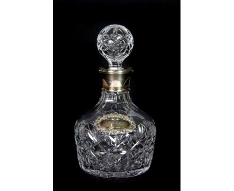 A silver mounted cut glass decanter, with silver spirit label.