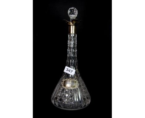 A silver mounted cut glass decanter with silver spirit label.