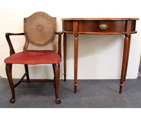 A mahogany console table and a cane backed chair.