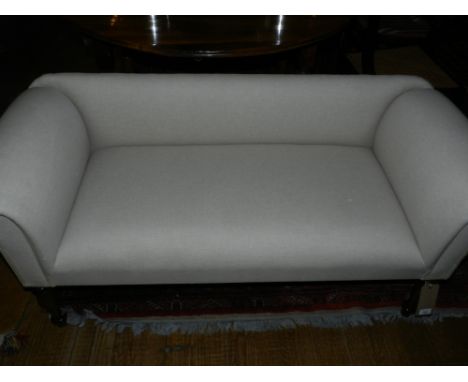 A contemporary sofa, upholstered in stone coloured linen, raised on turned legs. H: 63cm D: 54cm L: 135cm