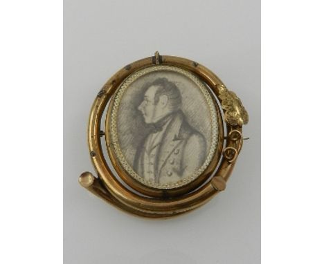 A late Victorian pinchbeck portrait brooch, set earlier 19th century pencil portrait of a gentleman. 