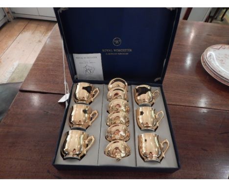 A set of six Royal Worcester creme de chocolat cups, decorated in gilt, bears factory mark to base, cased.
