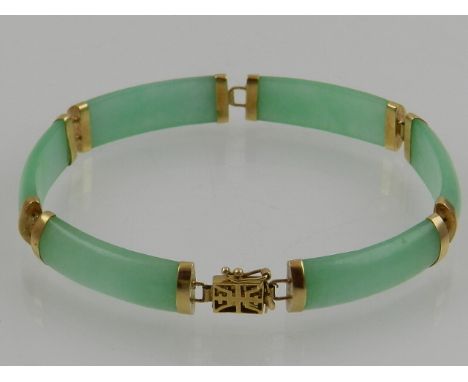 A 14 carat yellow gold and jade segmented bracelet, in the Chinese taste. 