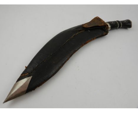 A Kukri, having engraved blade and leather scabbard.