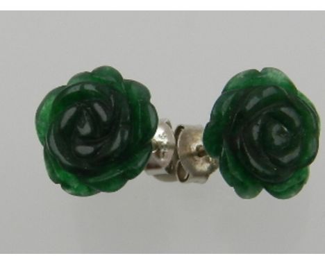A pair of carved jade and white metal flower head ear studs.