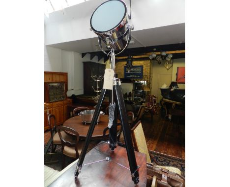 An adjustable chrome studio lamp, on tripod base.