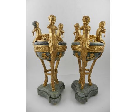 A pair of French Louis XVI style brule-perfum, having three putti to edge playing the flute, on three feet, raised on a marbl