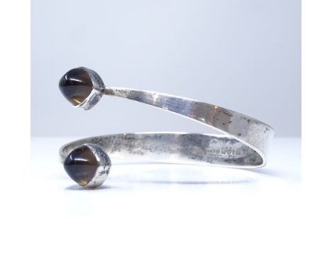 A Gert Thysell for Gussi Swedish silver and smoky quartz modernist torque bangle, each terminal set with a high cabochon smok