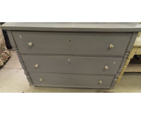 A continental painted pine three drawer commode with white china handles