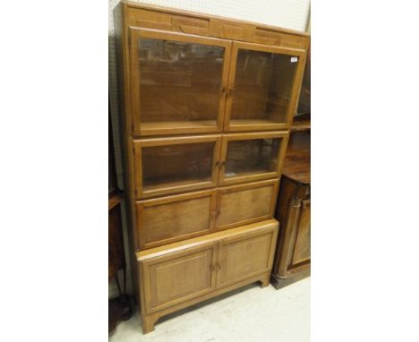 An early 20th Century Globe Wernicke type oak four section bookcase cabinet with Art Deco style decoration to top