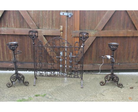 A pair of wrought iron ale warmers with floral decoration, together with a similar wrought iron fire screen with vase shaped 