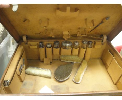 A vintage leather vanity case and contents of various silver mounted cut glass bottles, brushes, etc