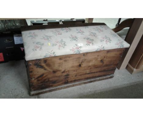 A stained pine trunk with floral upholstered lid
