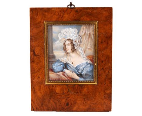 A 19th Century seated BUST PORTRAIT on Ivory of a young lady in blue costume with fancy head dress&nbsp;9.5cm by 8cm - glazed