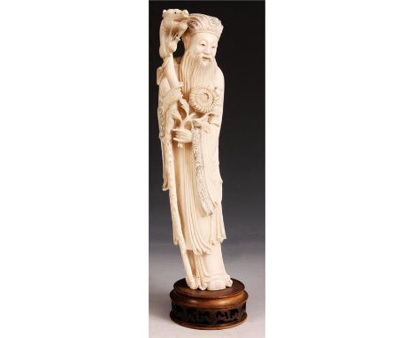 A carved Ivory standing FIGURE of a SAGE holding a dragons head walking stick and flower spray, on a carved wood base&nbsp;35