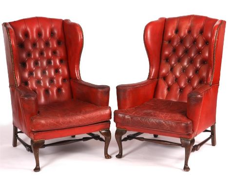 A good pair of Red Leather Button Backed WING ARMCHAIRS with shaped backs and cushion seats; on cabriole legs joined by H str
