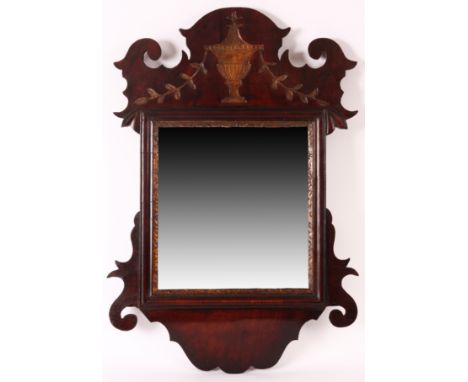 A small George III Mahogany shaped HANGING MIRROR with gilt carved urn to the top and scrolled cushion moulded frame; origina