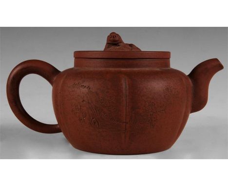 A Chinese Terracotta TEAPOT and COVER with dog o foe finial the squat panelled body with an incised prunus blossom spray reve