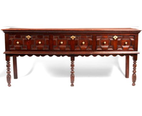 A 17th Century joined Oak moulded front low DRESSER of good colour and patina fitted three drawers to the frieze with brass k