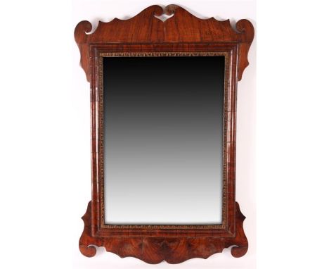 A good 18th Century Walnut cushion framed HANGING MIRROR with shaped scrolled frame; fitted with an original mirror plate 84c