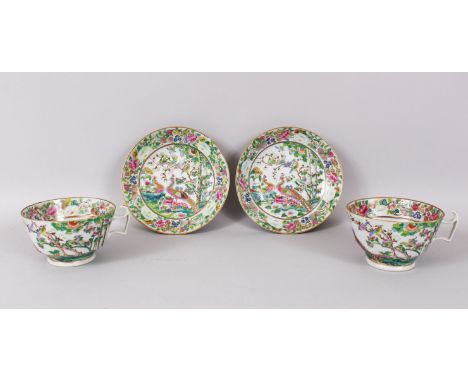 A LARGE PAIR OF CANTON CUPS AND SAUCERS, 11cm diameter, painted with brilliant coloured birds and flowers.