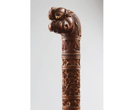 A 19TH CENTURY SOUTH INDIAN MYSORE CARVED SANDLEWOOD WALKING STICK, CIRCA 1900, with carved stem and dragon handle, 96cm long